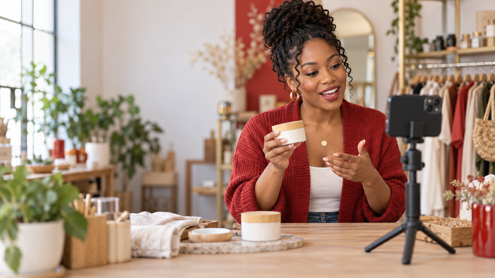 Black small business owner recording a short product demonstration video on a smartphone in her shop